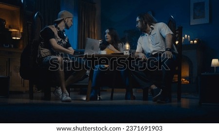 Medium-sized photo capturing two ghost hunters and a victim sitting at the table. The woman is explaining what is happening in her house, asking for help.