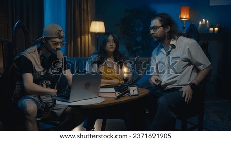 Medium-full photo capturing two ghost hunters and a victim sitting at the table. The woman is explaining what is happening in her house, asking for help.