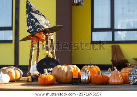 Autumn decor on the porch of the house outside in the yard of pumpkin, lantern, garlands, hats, jack lantern. Halloween party, autumn mood, Harvest festival