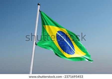 Waving flag of Brazil. Beautiful flag of the Federative Republic of Brazil on a street flagpole. Royalty-Free Stock Photo #2371695453