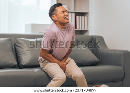 Prostate cancer and men's health, Middle-aged Asian Indian man grappling with testicular discomfort. Vivid portrayal of male health challenges, urging awareness and timely medical consultations. Royalty-Free Stock Photo #2371704899