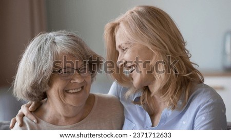 Cheerful elder grey haired 80s mother and grownup mature daughter smiling with love, affection, talking, laughing, smiling, enjoying family leisure time. Banner shot