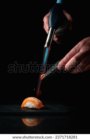 Scorching, Flaming sushi with a torch
Roasting sushi with a burner on a dark background Royalty-Free Stock Photo #2371718281