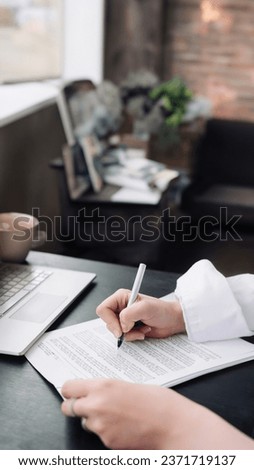 Young Woman's Hand Signing Official Document. Business, Legal, Finance, Notary, Trade, Credit, Accounting Concept. Woman signing an official document, a woman's hand with a pen signs a paper contract