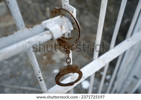                             Prison Handcuffs hang on Jail  Royalty-Free Stock Photo #2371725197