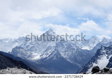 Aerial photography of mountain range covered with snow under white and blue sky at daytime