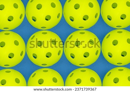 Close up of several pickleball balls on court.