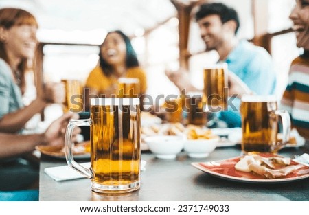 Happy people drinking beer at brewery pub restaurant - Group of friends enjoying happy hour sitting at bar table - Brewery life style concept with guys and girls dining together Royalty-Free Stock Photo #2371749033