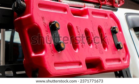 Close-up object photo of a red tank for additional gasoline for off-road needs, fuel reserves in an off-road car in preparation for going to the forest.