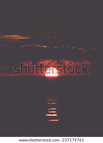 beautiful sunrise in the sea at the wild beach - retro, vintage style look