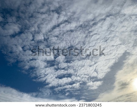 White altocumulus clouds floating in a raft, not far apart There was only a small space between the blocks light from the sun filtering through in sky at Bangkok, Thailand.no focus Royalty-Free Stock Photo #2371803245