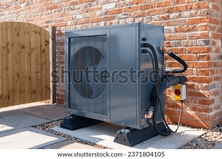 Air Source heat pump fitted outside a new home Royalty-Free Stock Photo #2371804105