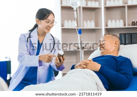 Caring female doctor provides attentive medical care to asian people elderly man lying in hospital bed, highlighting importance of expert healthcare and support during times of illness.