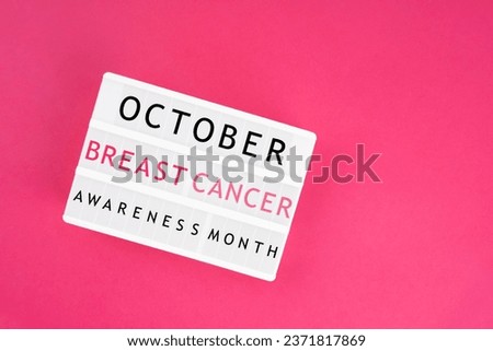 Lightbox displaying the text "October Breast Cancer Awareness Month" on pink color background. Medical concepts.