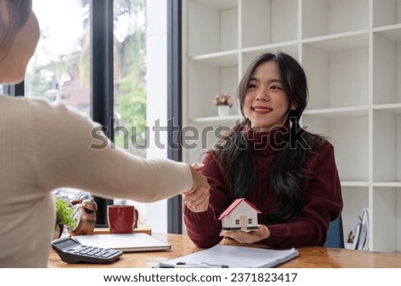 The bank mortgage officer or real estate agent handshake with customer deal after signing a house insurance, loan contract agreement