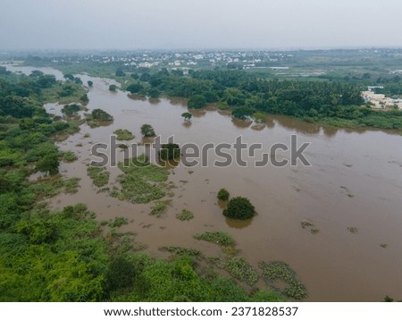 drone shot aerial view top angle panoramic photograph of massive river running through city riverbank flood water rain irrigation dam reservoir checkdam greenery agricultural fields fertile india 
