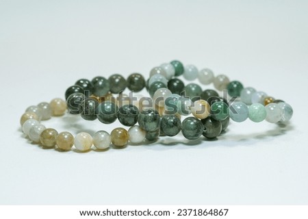 Natural jade gemstone beaded bracelet display on white background Royalty-Free Stock Photo #2371864867