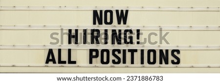 A changeable letter sign from a business telling viewers, "Now Hiring! All Positions." 