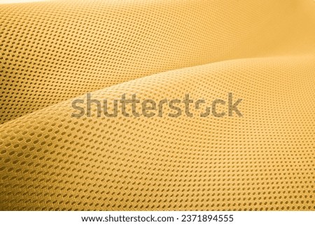 Rough yellow fabric texture, cotton knitted fabric, modern waterproof flexible temperature control materials, multifunctional smart textile close-up, selective focus, does not tear.