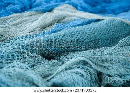 pile of blue fishing net with white floats. Trawler fishing net and floats. Fishing nets and ropes. tool for catching fish Royalty-Free Stock Photo #2371903175