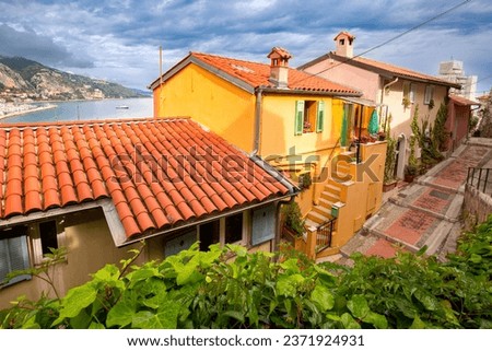 Colorful cosy street and houses in the Old Town of Menton, French Riviera, France Royalty-Free Stock Photo #2371924931