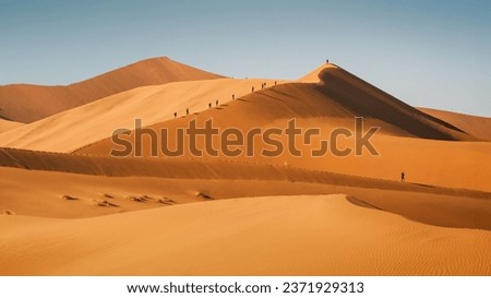 People climbing sand dunes in Sossusvlei area, Namib-Naukluft National Park, Namibia enjoying from their summit stunning view of the world’s oldest desert, the Namib Desert. Royalty-Free Stock Photo #2371929313