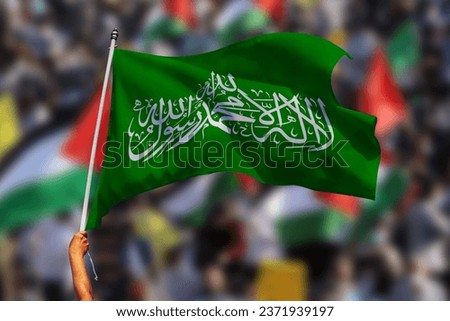 A man holding a Hamas flag waving on Palestinian solidarity rallies around the world in support of Palestine Royalty-Free Stock Photo #2371939197
