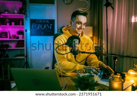 One man caucasian male blogger or vlogger gesticulating while streaming video podcast in broadcasting studio use microphone and headphones famous influencer shooting video for channel podcast
