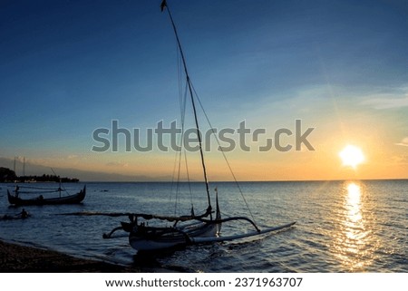Traditional fishing boat, anchored on the beach at dusk
