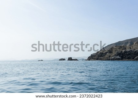 View of the mountain, rocks, seaweed and guano under the shining afternoon sun, near the sea, Playa Tortugas, Casma, Ancash - Peru Royalty-Free Stock Photo #2372022423