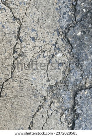 a photography of a close up of a crack in the ground, a close up of a street with cracks and cracks in it.