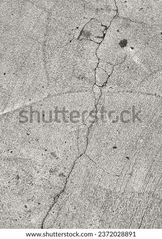 a photography of a fire hydrant sitting on the side of a road, concrete surface with cracks and cracks in it.