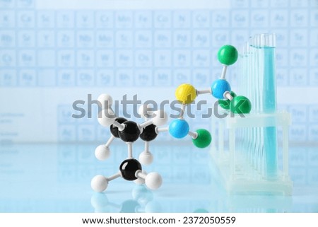 Molecular model and test tubes on light surface