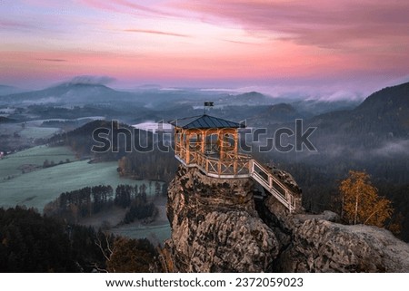 Jetrichovice, Czech Republic - Aerial view of Mariina Vyhlidka (Mary's view) lookout with foggy Czech autumn landscape and colorful pink sunrise sky in Bohemian Switzerland National Park Royalty-Free Stock Photo #2372059023