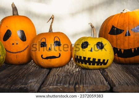 Pumpkins with drawn spooky faces on grey background. Halloween celebration