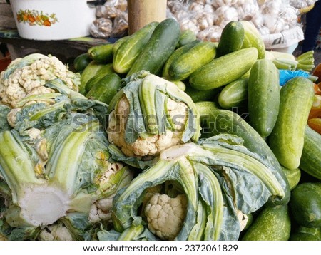 piles of cauliflower and cucumbers at a traditional market