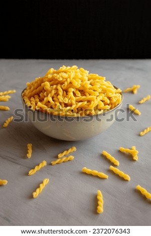 Uncooked Dry Gemelli Pasta in a Bowl, side view. Royalty-Free Stock Photo #2372076343