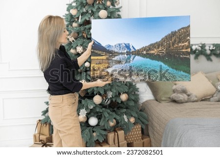 Canvas prints. A woman holding photograph with gallery wrap. Landscape photo printed on glossy synthetic canvas and stretched on wooden stretcher bar