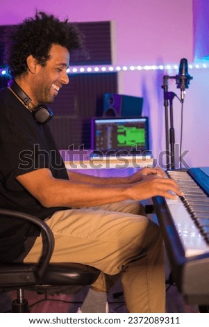 Vertical photo of a happy artist recording a new album in studio