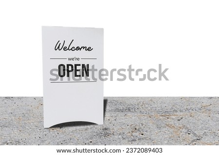 text on vintage white sign " welcome we' are Open" in cafe on concrete floor. isolated on white background.