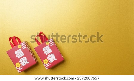 The characters for "Lucky bag" are written in Japanese.Gold background.Japanese lucky bag.An image of Japanese New Year. Royalty-Free Stock Photo #2372089657