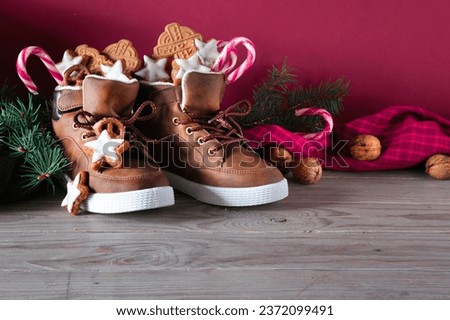 Saint Nicholas Day or Nikolaus, german holiday, December 6. Children shoes with traditional sweets. Royalty-Free Stock Photo #2372099491