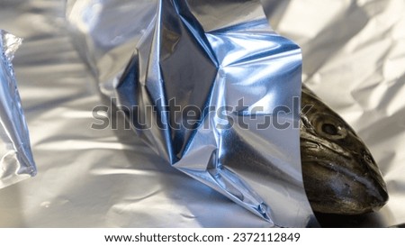 Trout in aluminium foil prepared for baking in oven