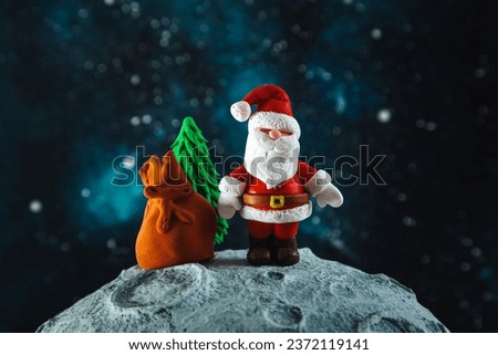 Plasticine Santa Claus with a bag of gifts and a Christmas tree on the moon. Christmas card.