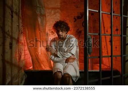 Frightened craze man psychiatric hospital patient looking at camera Royalty-Free Stock Photo #2372138555