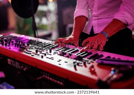 Musician playing electronic musical keyboard synthesizer Royalty-Free Stock Photo #2372139641