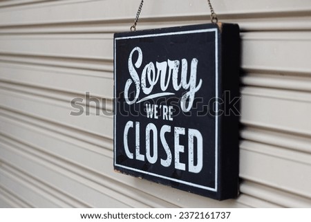 Sorry we're closed sign. grunge image hanging on a metal door.