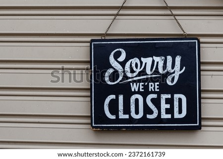Sorry we're closed sign. grunge image hanging on a metal door.