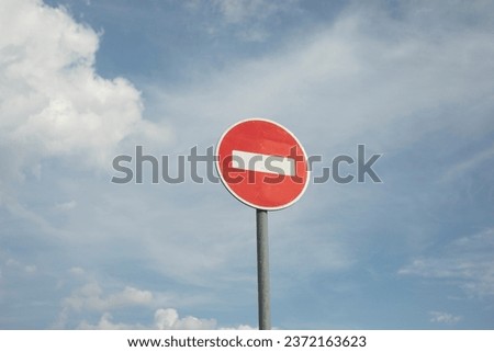 Stop sign on sky background. Road sign prohibiting traffic. Red circle and white line. Sign on pole.