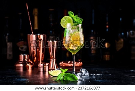 Hugo spritz cocktail drink with sparkling wine, elderflower syrup, soda, lime, mint and ice, dark bar counter background Royalty-Free Stock Photo #2372166077